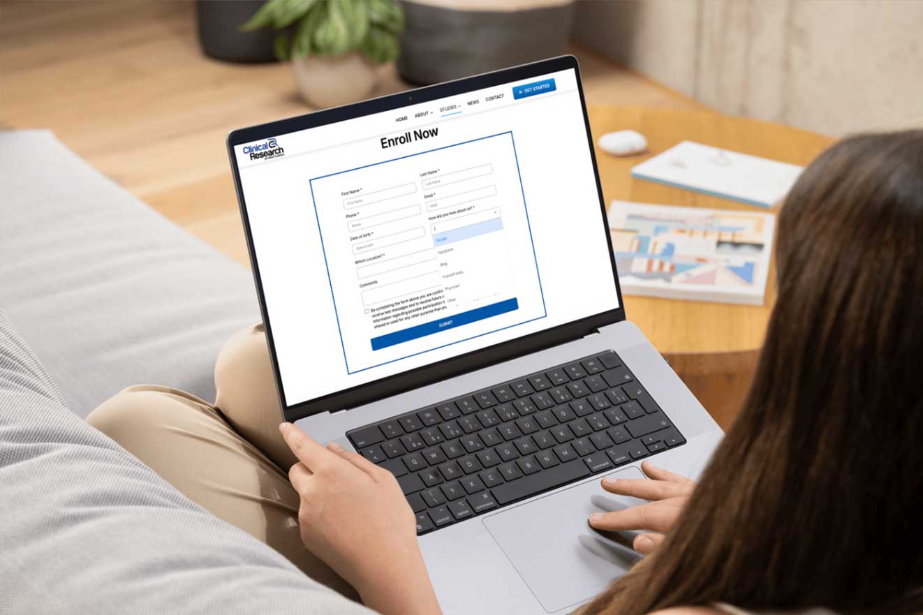 Person filling out an online enrollment form on a laptop, emphasizing the importance of accurate marketing attribution in data collection strategies.